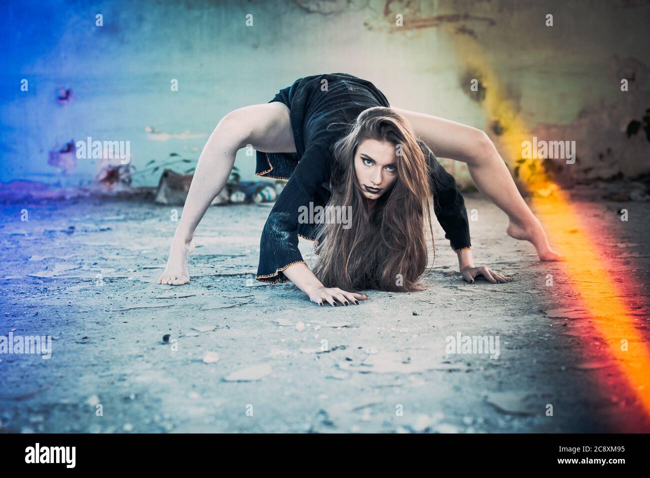 Ragazza vestita come strega, aspetto pazzo, in posa come ragno. Concetto di Halloween Foto Stock