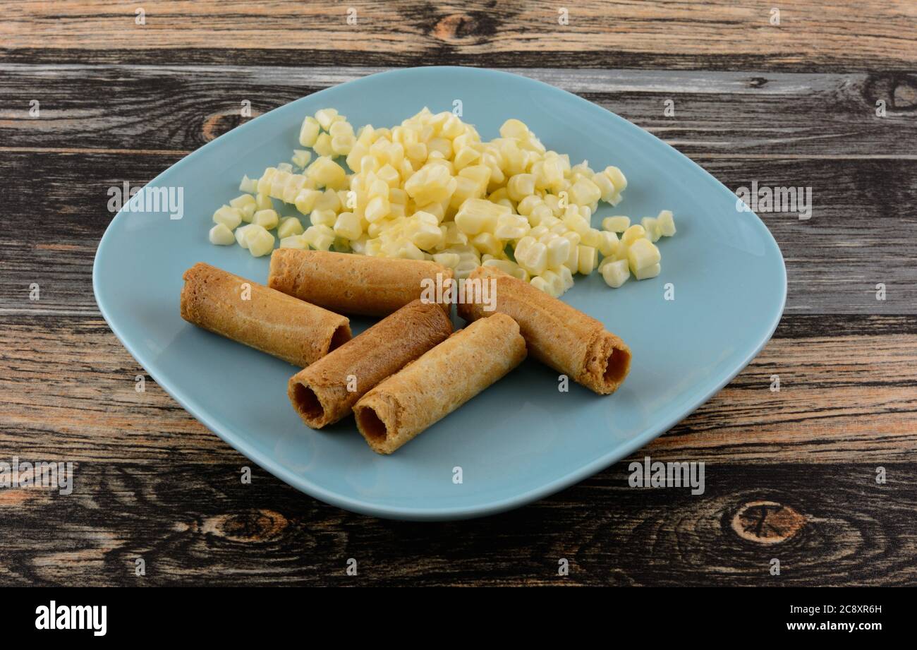 Panini di cocco con mais dolce tailandese con chicchi di mais dolce fresco su piatto di spuntini blu Foto Stock