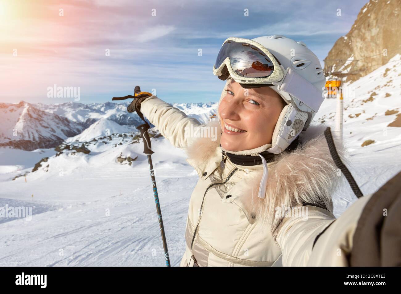 Giovane adulto bello felice attraente caucasico sorridente sciatore ritratto donna facendo selfie sulla cima della montagna mostrando panorama stazione sciistica Foto Stock