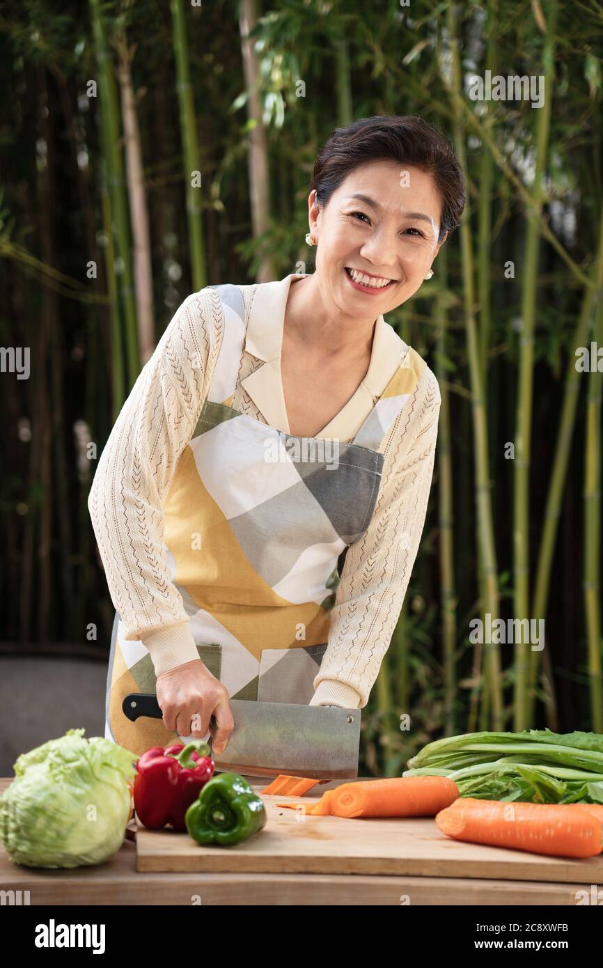 Il cortile tritare verdure in donne di mezza vita Foto Stock