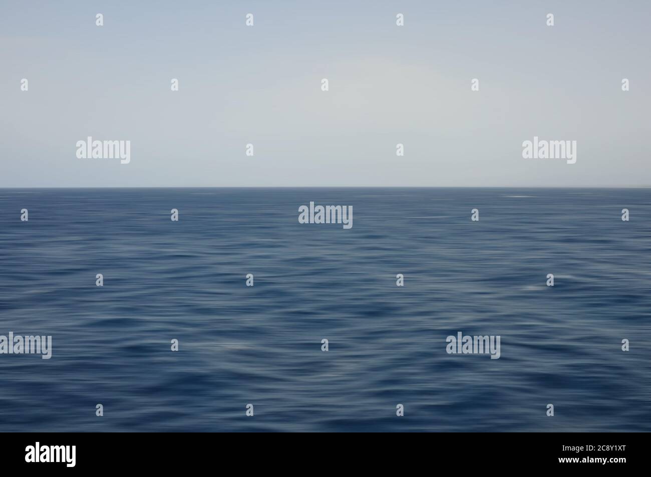 Onde di mare profondo e cielo blu. Sfondo sfocato con movimento astratto. Foto Stock