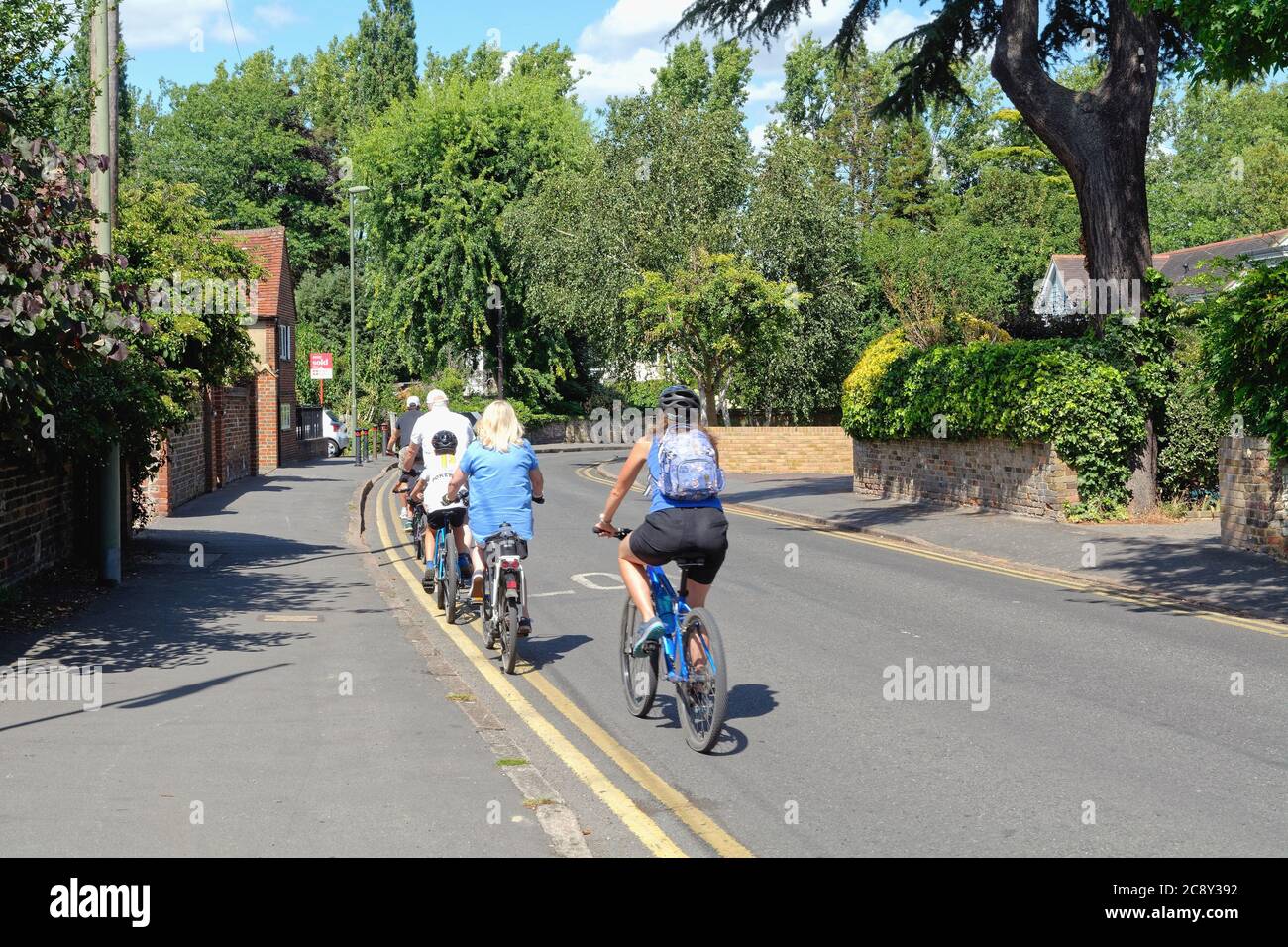 Una famiglia in bicicletta insieme su una strada tranquilla a Shepperton Surrey Regno Unito Foto Stock