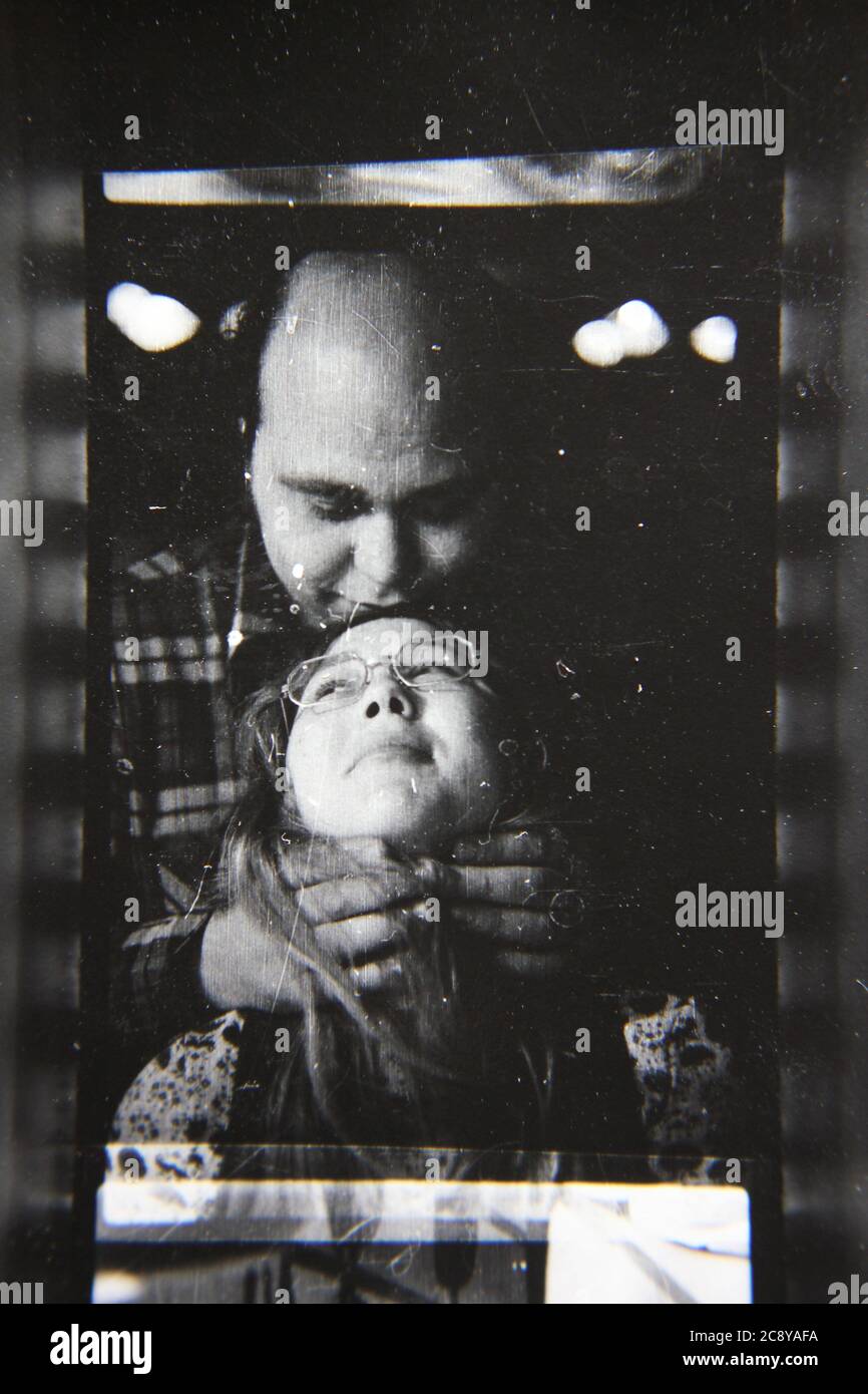 Bella fotografia in bianco e nero degli anni '70 di un uomo che gioca strangolando con sua moglie. Foto Stock