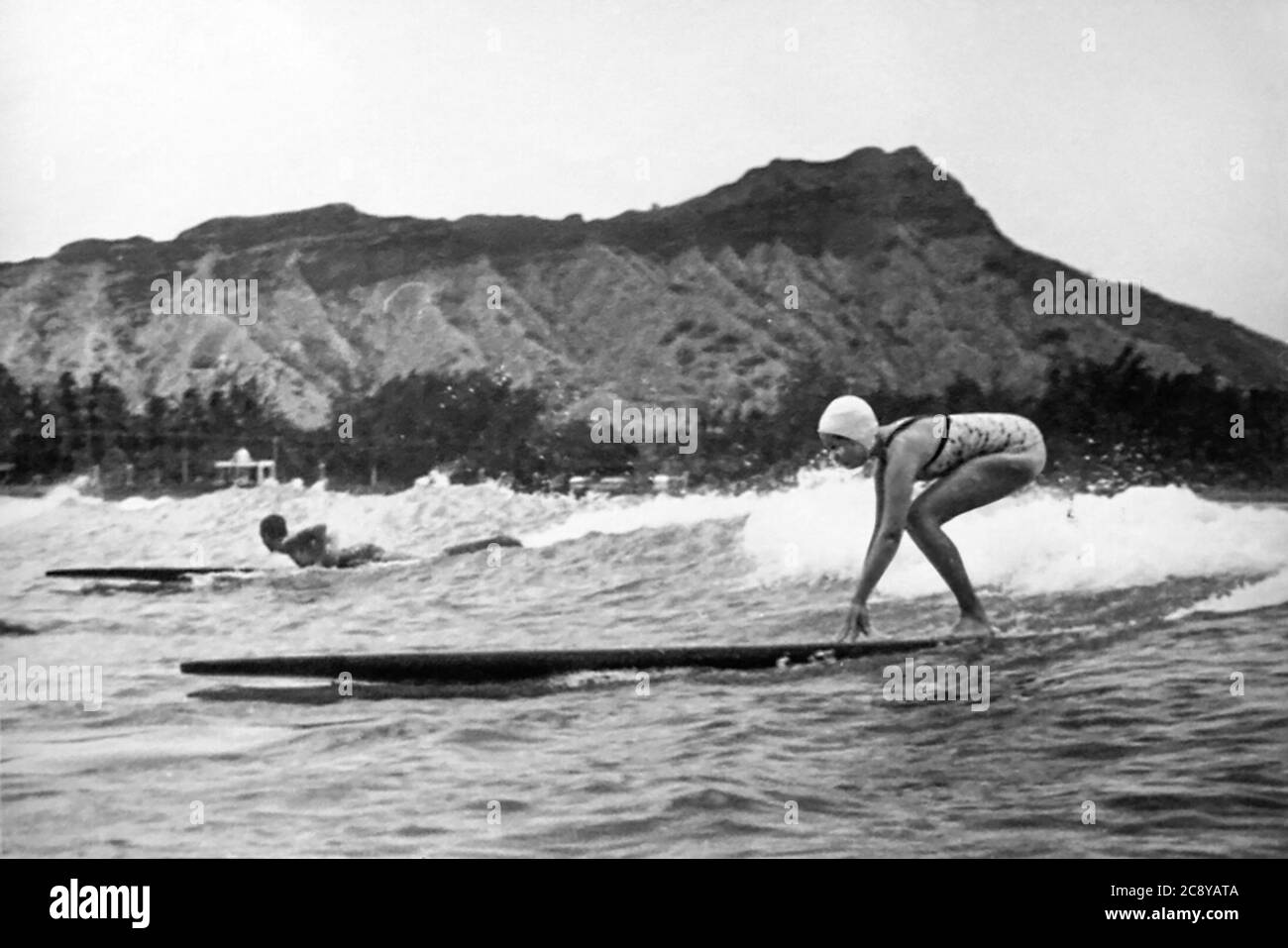 Giovane donna che naviga a Waikiki su un longboard in legno, anni 1920/1930. Foto Stock