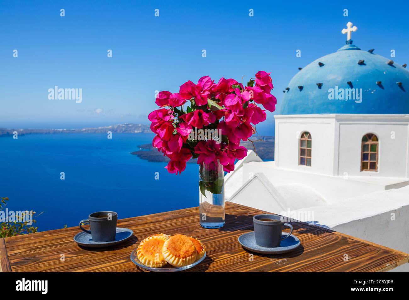 Tavolino sullo sfondo del mare e delle chiese di Santorini Foto Stock