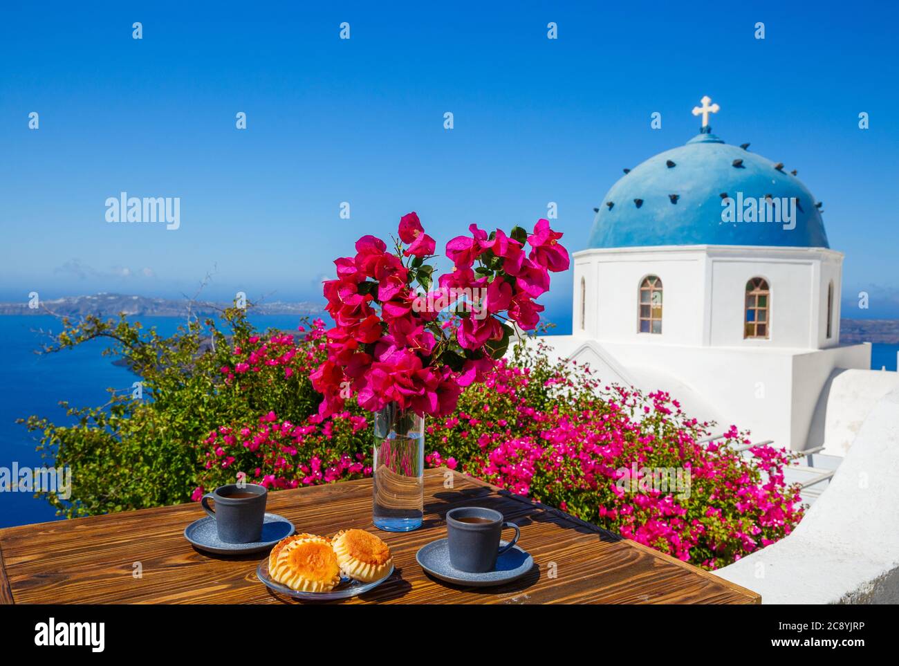 Tavolino sullo sfondo del mare e delle chiese di Santorini Foto Stock