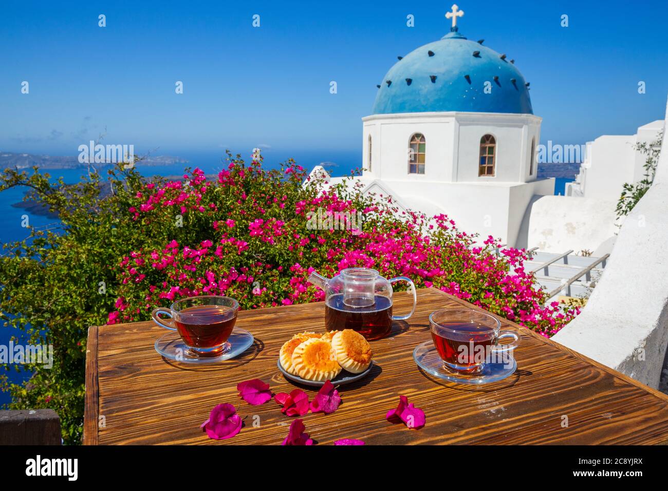 Tè e panini per due sullo sfondo del mare e l'isola di Santorini. Foto Stock