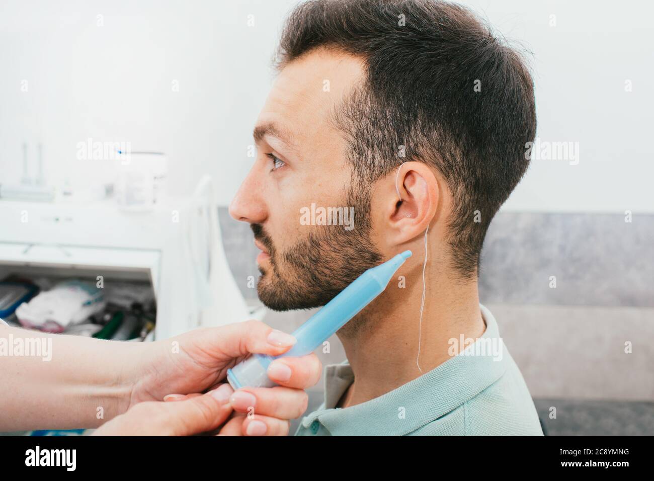 processo di stampaggio di auricolari individuali per apparecchi acustici. Un uomo, avendo procedura che fa gli auricolari individuali Foto Stock