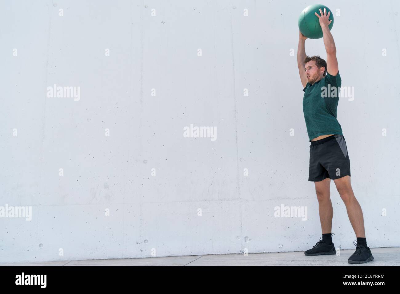 Fit uomo che getta palla di medicina sul workout a pavimento Foto Stock