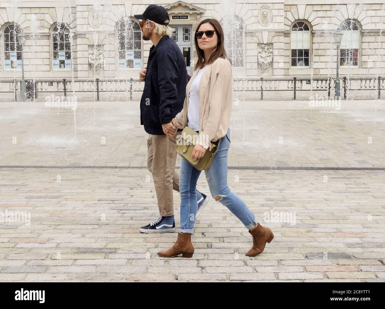 Una giovane coppia che cammina nel cortile della Somerset House, Londra, Regno Unito Foto Stock