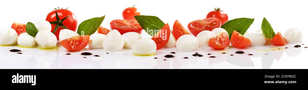 Mozzarella di pomodoro Panorama con basilico isolato su sfondo bianco Foto Stock