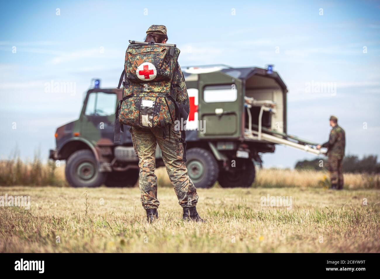 HANNOVER / GERMANIA - 24 GIUGNO 2020: Paramedico dell'esercito tedesco con uno zaino di emergenza si trova presso un'ambulanza militare Foto Stock