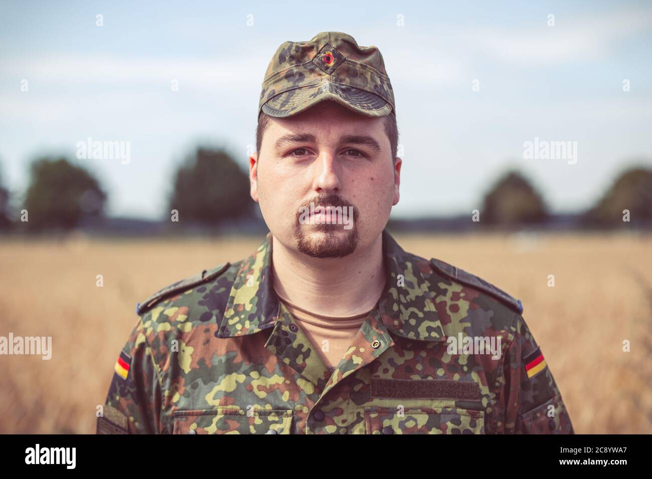 Ritratto di un soldato tedesco di fronte a un campo Foto Stock