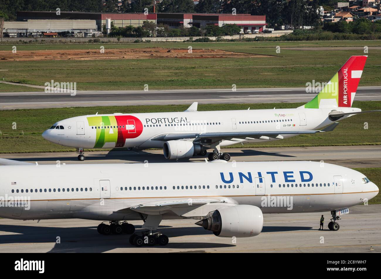 TAP Air Portugal Airbus A330-202 (CS-TOP - 'Pedro Nunes') passando da un Boeing 777 della United Airlines durante il tassamento a Sao Paulo/Guarulhos Intl. Aeroporto. Foto Stock