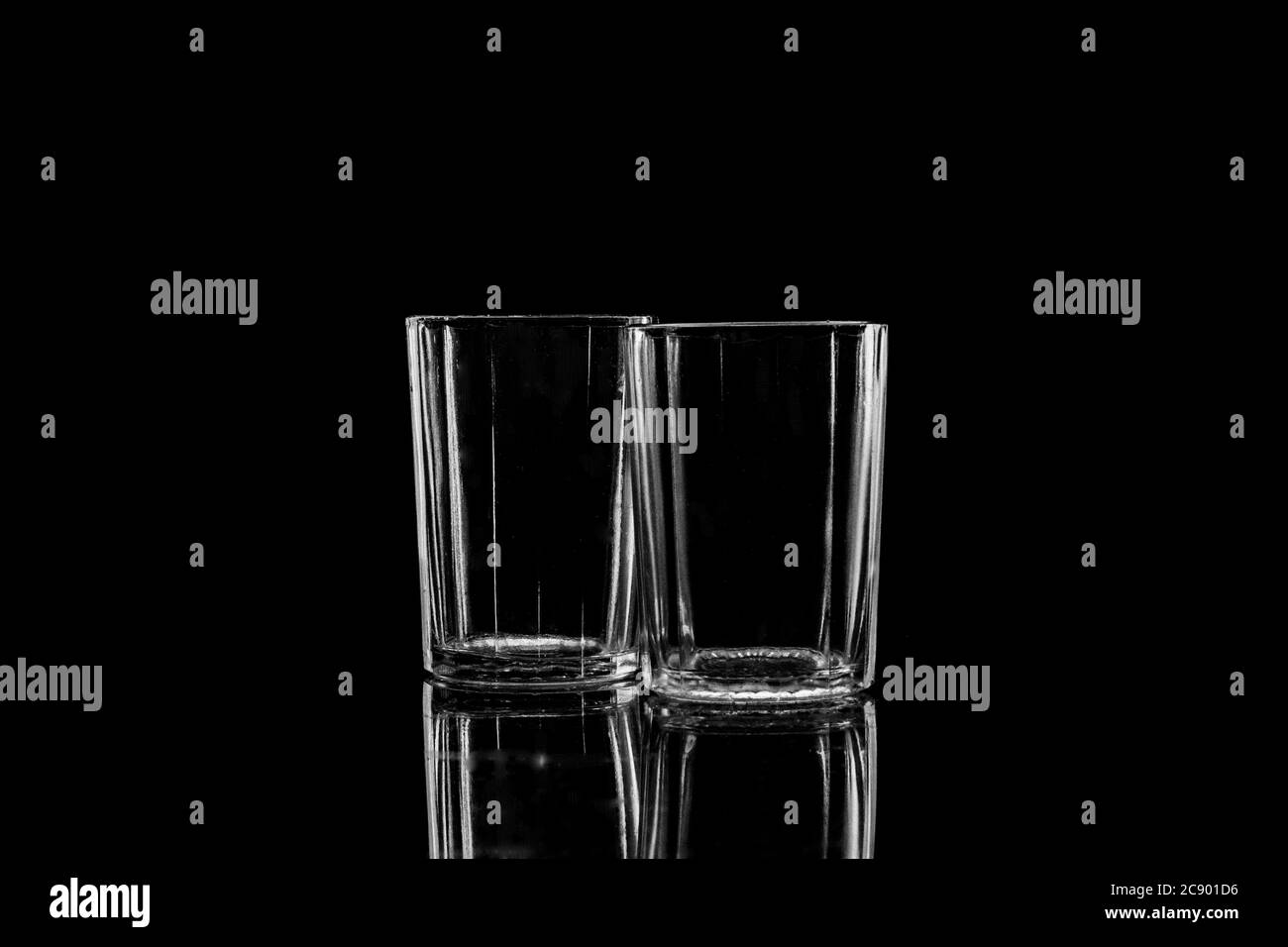 Low-key Studio Shot di una silhouette bianca di un vetro sfaccettato vetri luce isolato su uno sfondo nero. Linee e forme uniformi. Concetto. Foto Stock