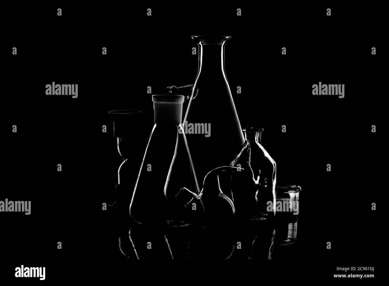 Low-key Studio Shot di una silhouette bianca di un laboratorio chimico utensili vetri luce isolati su uno sfondo nero. Linee e forme uniformi. Concetto. Foto Stock