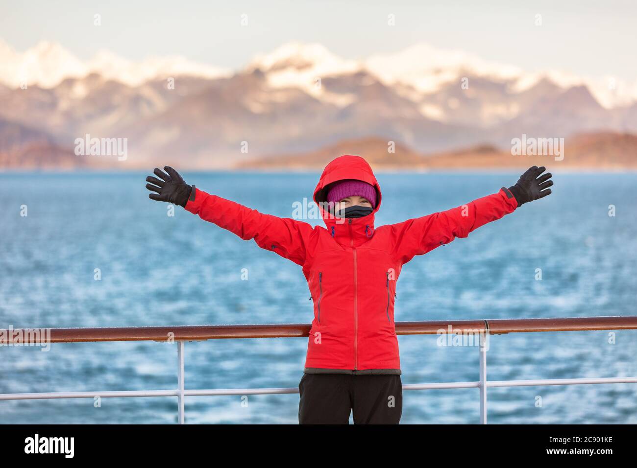 Alaska Glacier Bay crociera viaggio divertente turista eccitato guardando all'interno passaggio. Donna felice a braccia aperte in gioia di vedere paesaggio naturale dell'Alaska Foto Stock