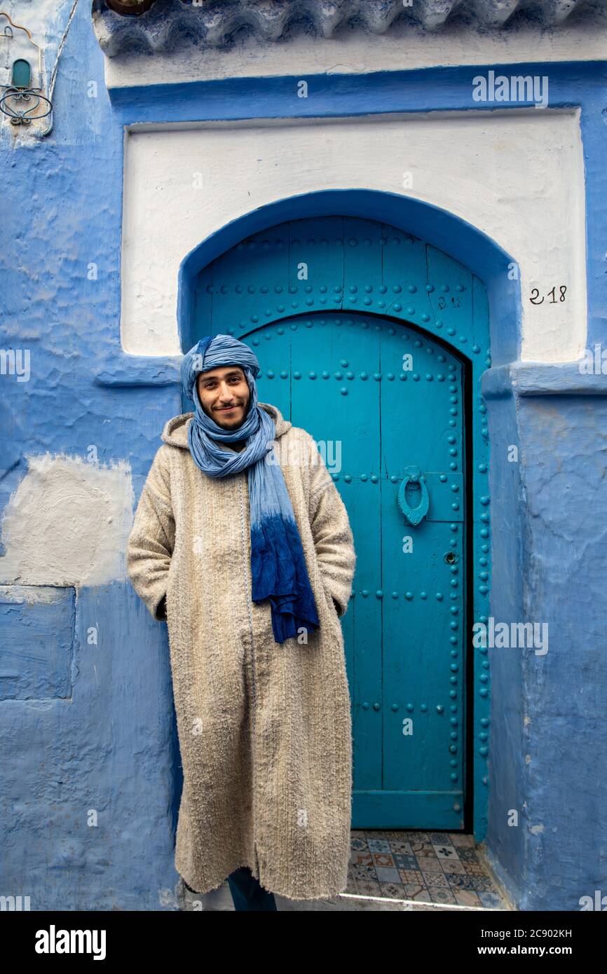 Un giovane berbero con turbano blu vende i suoi articoli nella città di Chefchaouen, Marocco, nelle montagne di Rif Foto Stock