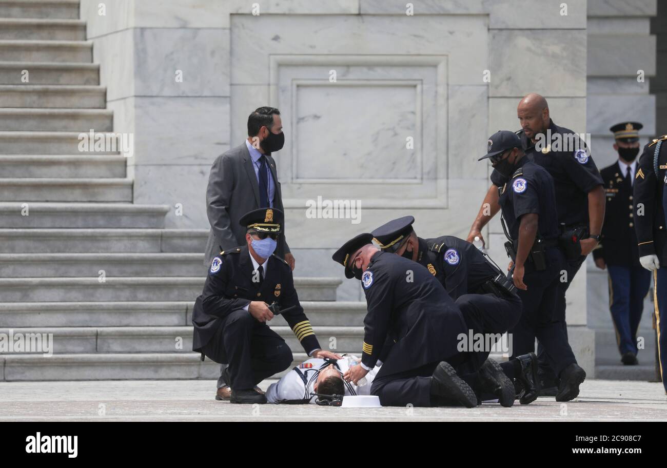 Un membro di una guardia militare d'onore degli Stati Uniti è controllato su dopo il crollo nel calore del giorno come un heard che porta il casket del pioniere dei diritti civili e rappresentante degli Stati Uniti John Lewis (democratico di Georgia), Morto il 17 luglio, arriva al Campidoglio degli Stati Uniti prima che Lewis si trovi nello stato all'interno della rotonda di Washington, Stati Uniti, il 27 luglio 2020. Credit: Leah Millis/Pool via CNP | utilizzo in tutto il mondo Foto Stock