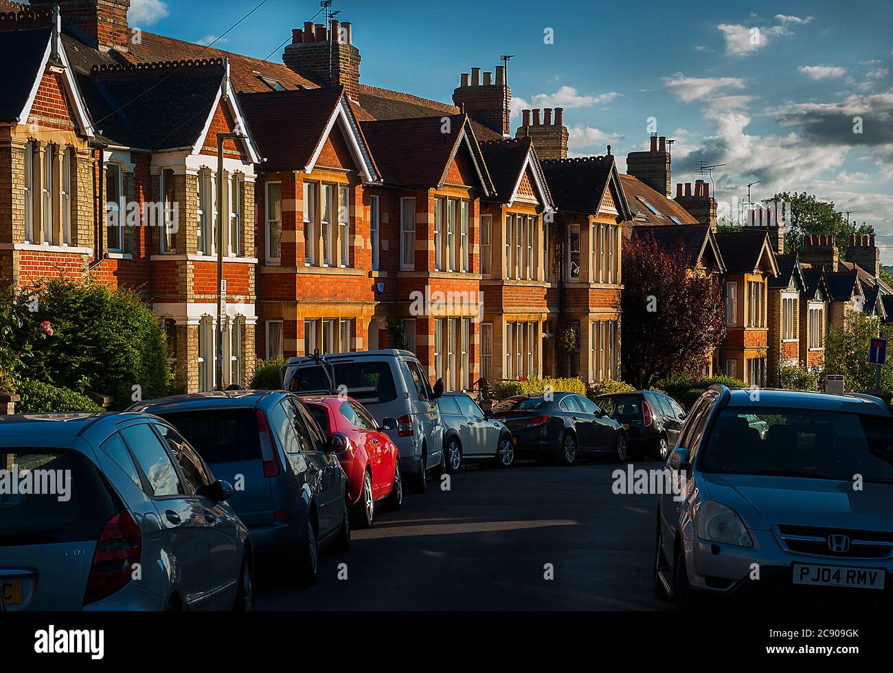 Ripida strada fiancheggiata da Urban Terrace Houses al tramonto Foto Stock