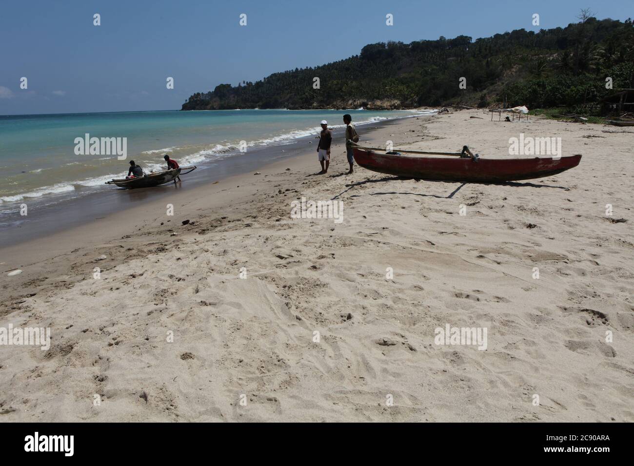 I pescatori tradizionali lanciano una canoa da pesca sull'acqua di mare a Wanokaka, l'isola di Sumba, Indonesia. Foto Stock