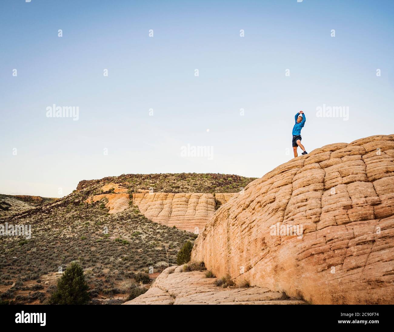 USA, Utah, St. George, Man che si estende in un paesaggio roccioso Foto Stock