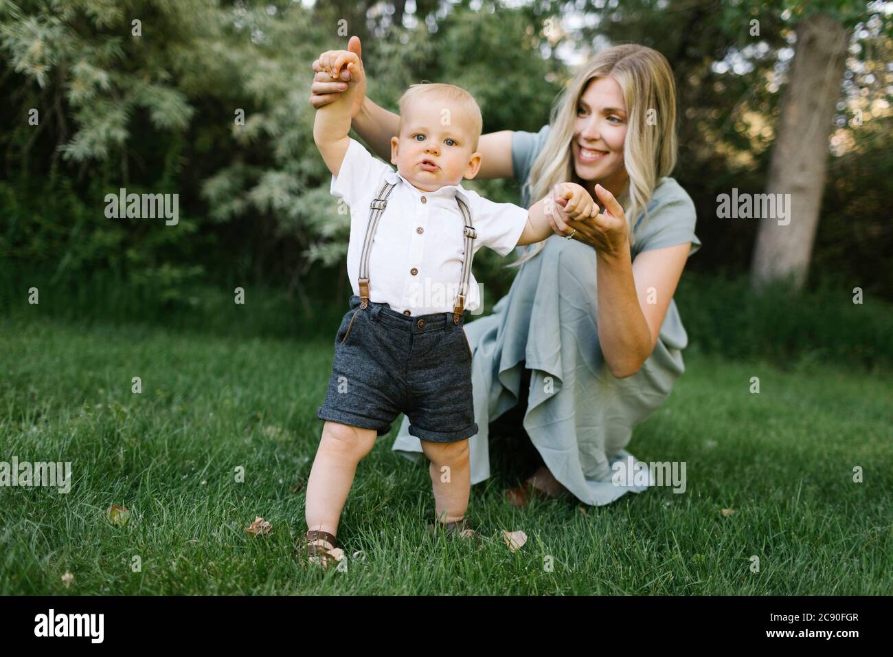 Madre con bambino figlio imparando a camminare nel parco Foto Stock