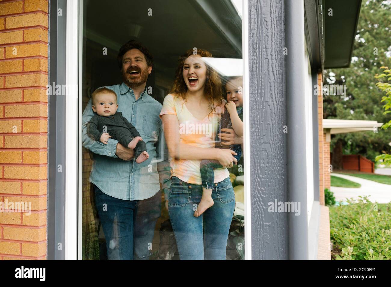 USA, Utah, Salt Lake City, Famiglia con i bambini (6-11 mesi, 2-3) che guardano attraverso la finestra Foto Stock