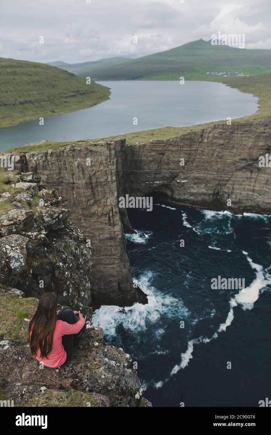 Danimarca, Isole Faroe, Lago Sorvagsvatn, Donna che guarda al paesaggio drammatico Foto Stock