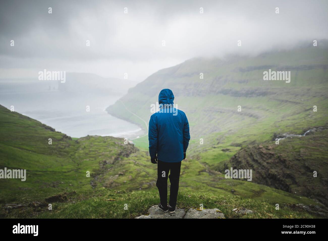 Danimarca, uomo in piedi sulla scogliera sopra il mare e guardando la vista Foto Stock
