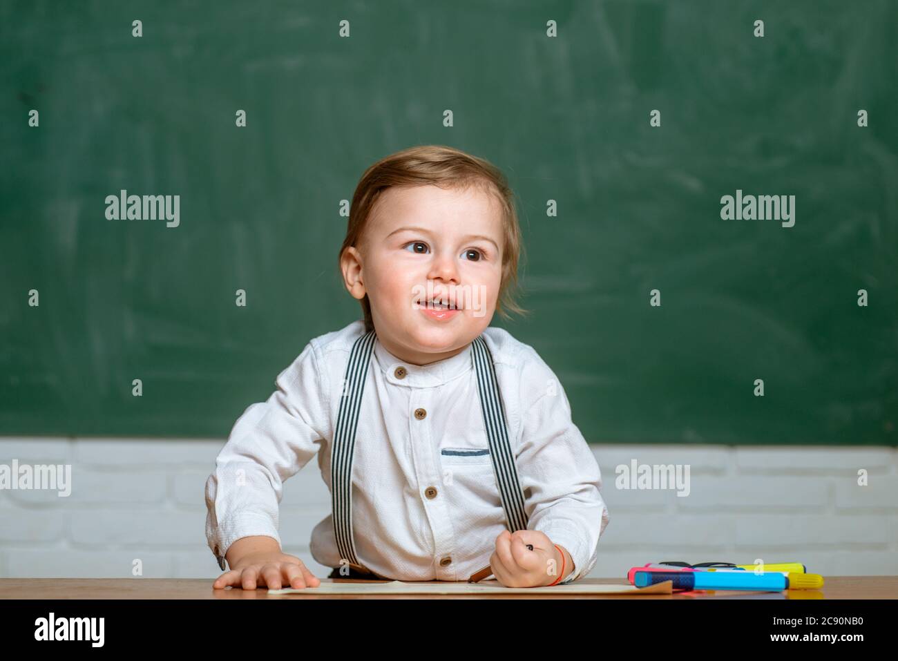 Il preschooler sta imparando in classe. Bambini in età prescolare a lezione. Spazio di copia della lavagna. Poco pronto a studiare. Foto Stock