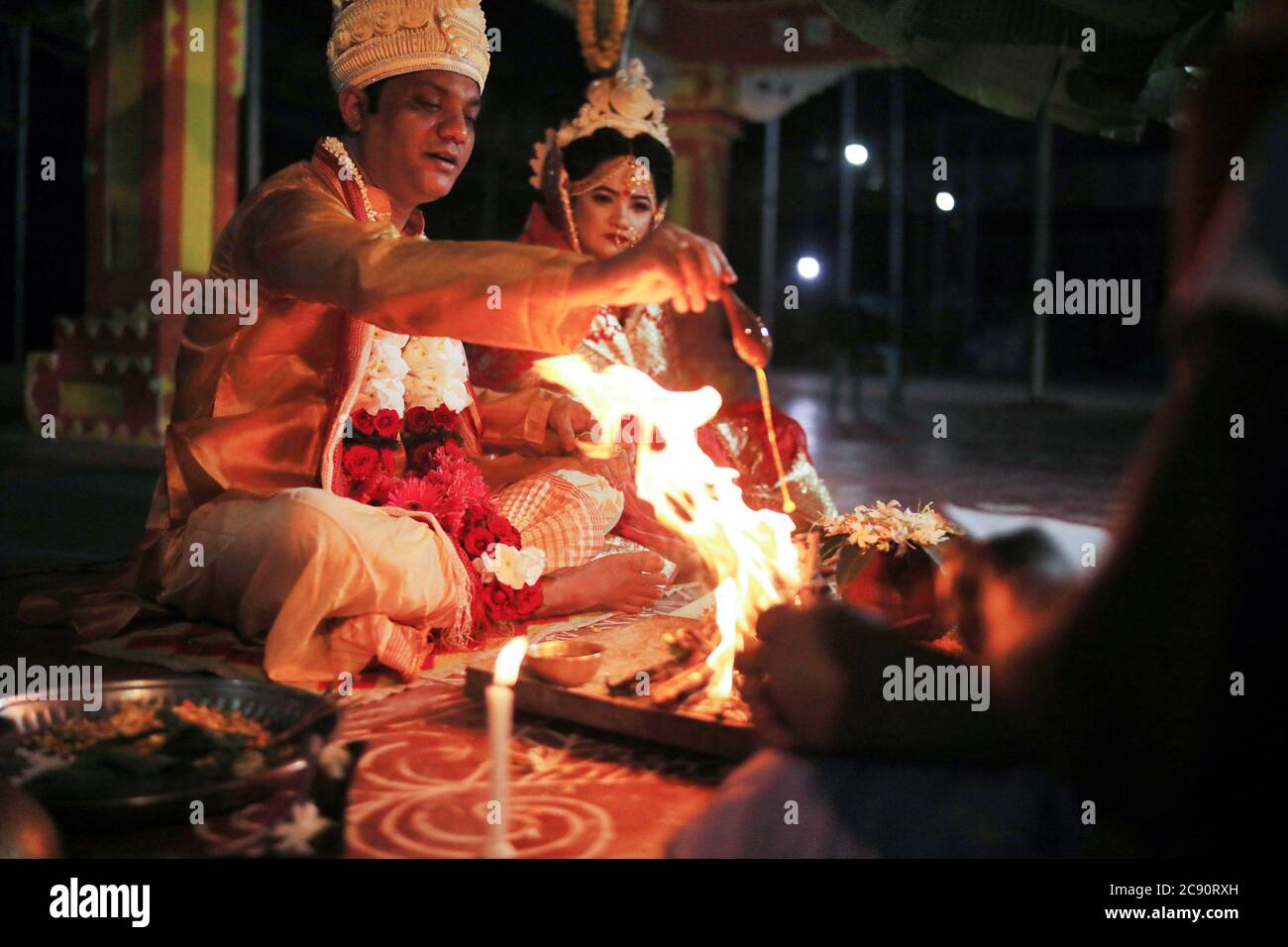 Dhaka, Bangladesh. 25 Giugno 2020. La coppia del Bangladesh esegue rituali di nozze secondo le tradizioni indù durante la crisi del Coronavirus al tempio di Ramna a Dhaka. Una cerimonia di nozze indù si è svolta in un tempio locale a Dhaka, in mezzo a pandemia di coronavirus. Sono stati invitati a partecipare a questo programma pochissimi ospiti a causa di problemi di sicurezza. Credit: SOPA Images Limited/Alamy Live News Foto Stock