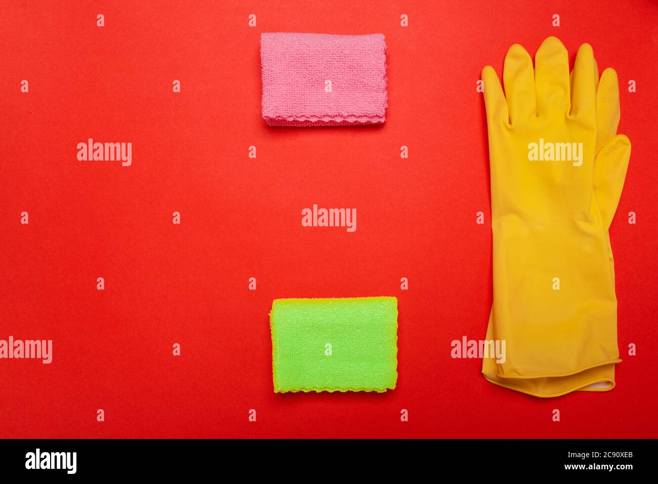 guanti e stracci su sfondo rosso. CopySpace Foto Stock