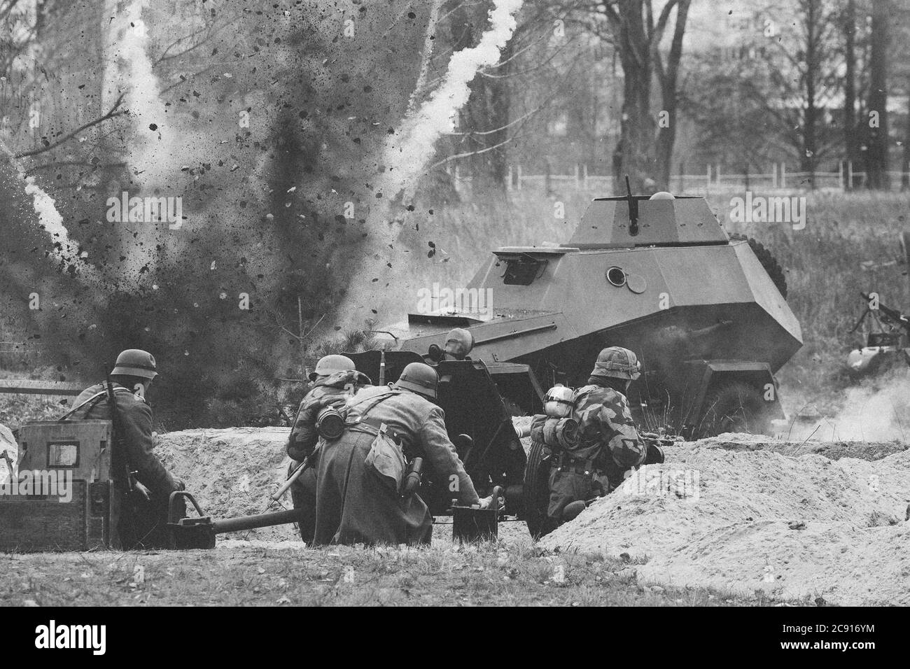 I re-enattori vestiti come soldati tedeschi nella seconda guerra mondiale sono combattimenti Tiro con un cannone sulla macchina armata russa sovietica durante la storia Foto Stock