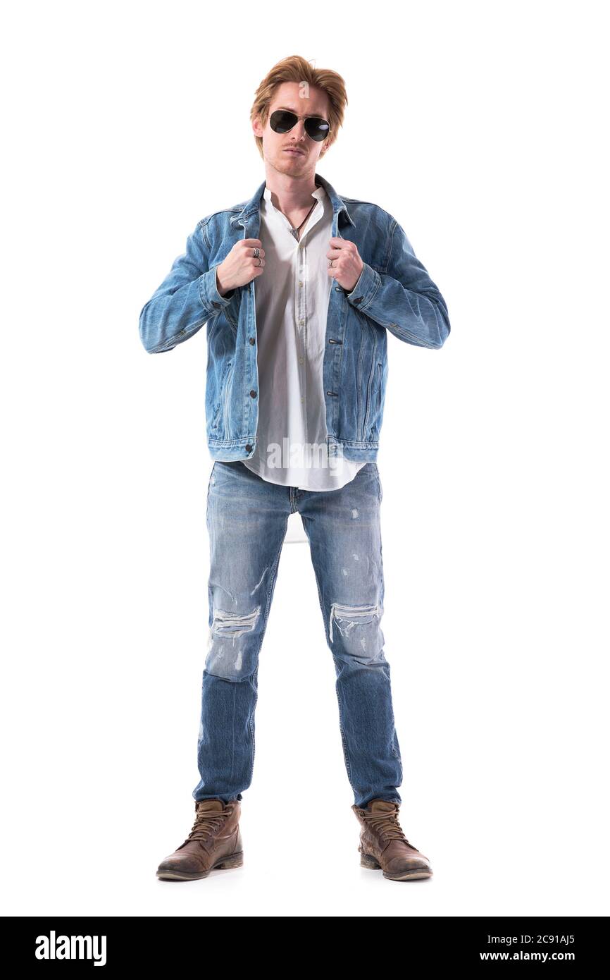 Elegante giovane uomo bello vestirsi con giacca in denim guardando la macchina fotografica. Lunghezza totale del corpo isolata su sfondo bianco. Foto Stock