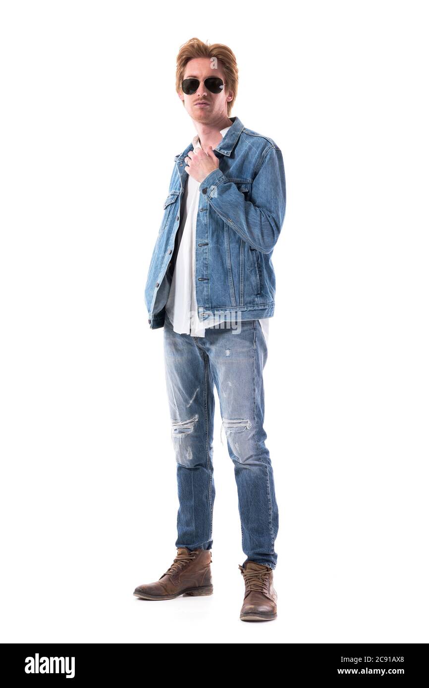 Vista laterale del bel giovane uomo elegante che indossa jeans e giacca in  denim guardando la macchina fotografica. Lunghezza totale del corpo isolata  su sfondo bianco Foto stock - Alamy