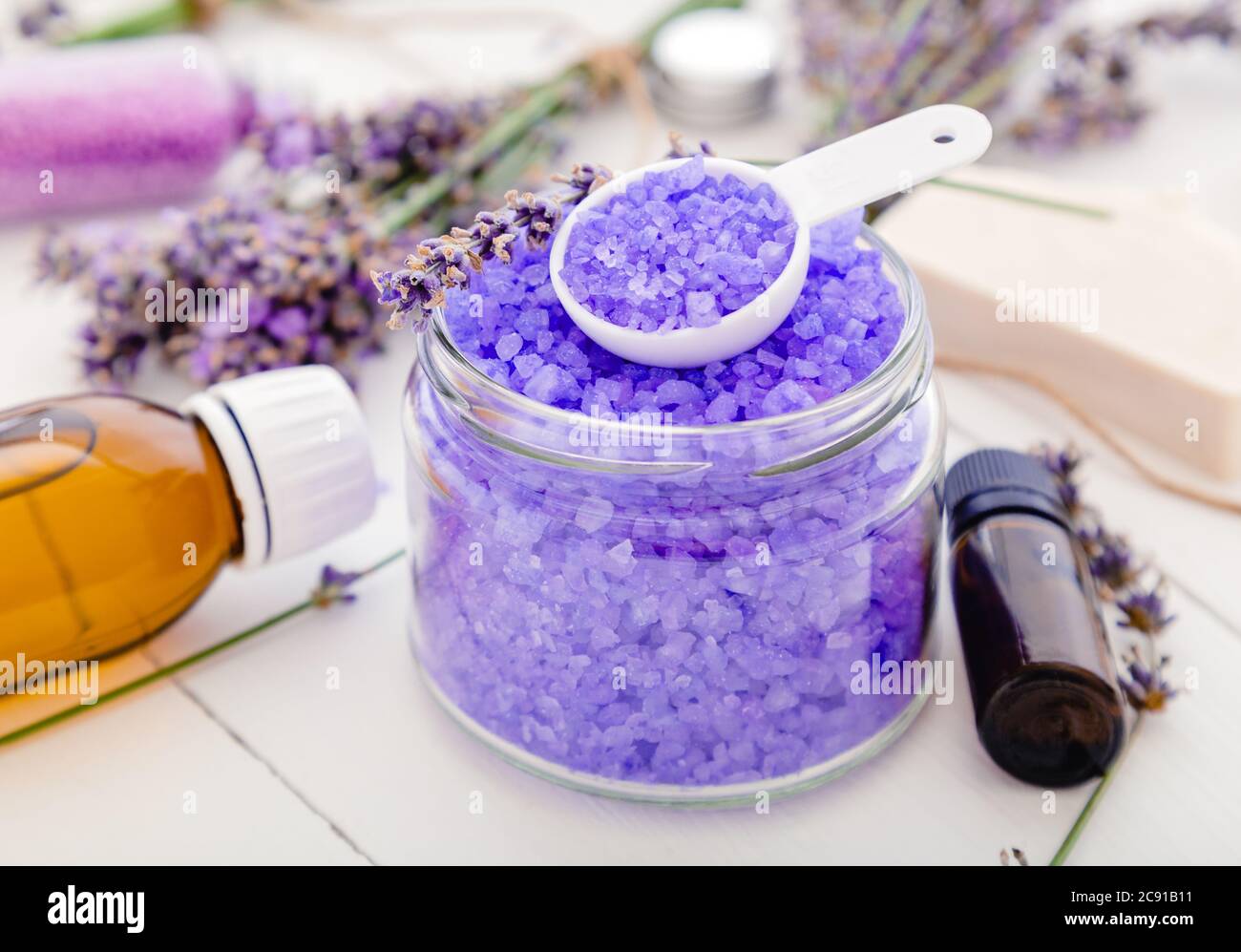 Sale marino viola di lavanda con olio essenziale e fiori di lavanda.  Prodotti da bagno alla lavanda trattamento aromaterapico su sfondo di legno  bianco. Cura della pelle Foto stock - Alamy