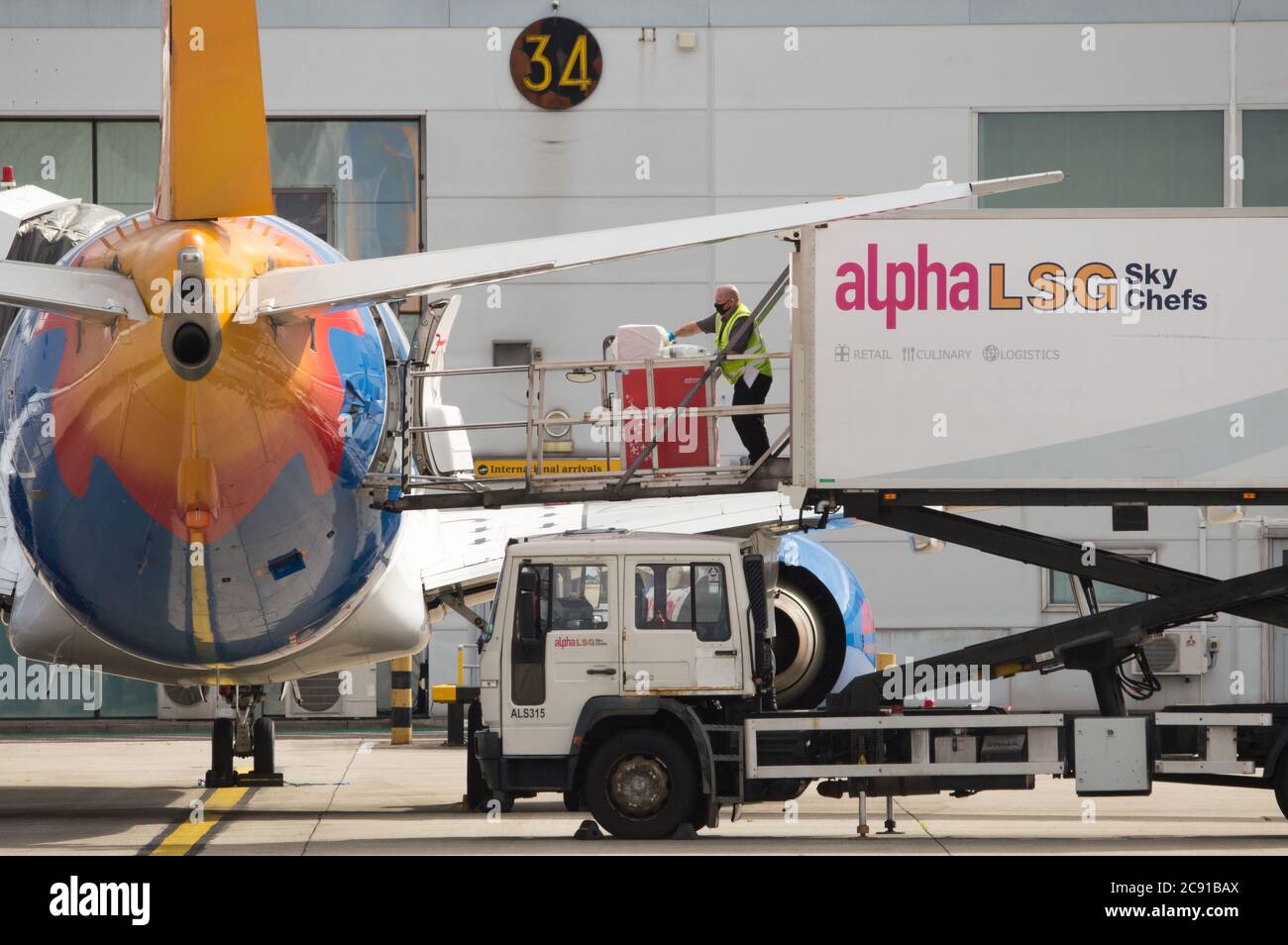 Glasgow, Scozia, Regno Unito. 28 luglio 2020. Nella foto: Gli equipaggi aeroportuali di terra di LSG Sky Chefs caricano i servizi di catering dei carrelli per cibo e bevande su un Jet2 Boeing 737-86N (Reg: G-DRTB) destinato a Dalaman, Turchia. Oggi, Jet2 Holidays annulla tutti i voli per Tenerife, Fuerteventura, Gran Canaria, Lanzarote, Maiorca, Minorca e Ibiza dopo che gli uffici esteri hanno consigliato di non-essenziale viaggio per le isole. Credit: Colin Fisher/Alamy Live News Foto Stock