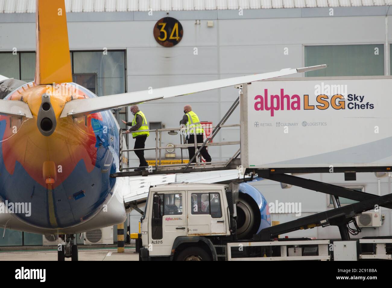 Glasgow, Scozia, Regno Unito. 28 luglio 2020. Nella foto: Gli equipaggi aeroportuali di terra di LSG Sky Chefs caricano i servizi di catering dei carrelli per cibo e bevande su un Jet2 Boeing 737-86N (Reg: G-DRTB) destinato a Dalaman, Turchia. Oggi, Jet2 Holidays annulla tutti i voli per Tenerife, Fuerteventura, Gran Canaria, Lanzarote, Maiorca, Minorca e Ibiza dopo che gli uffici esteri hanno consigliato di non-essenziale viaggio per le isole. Credit: Colin Fisher/Alamy Live News Foto Stock