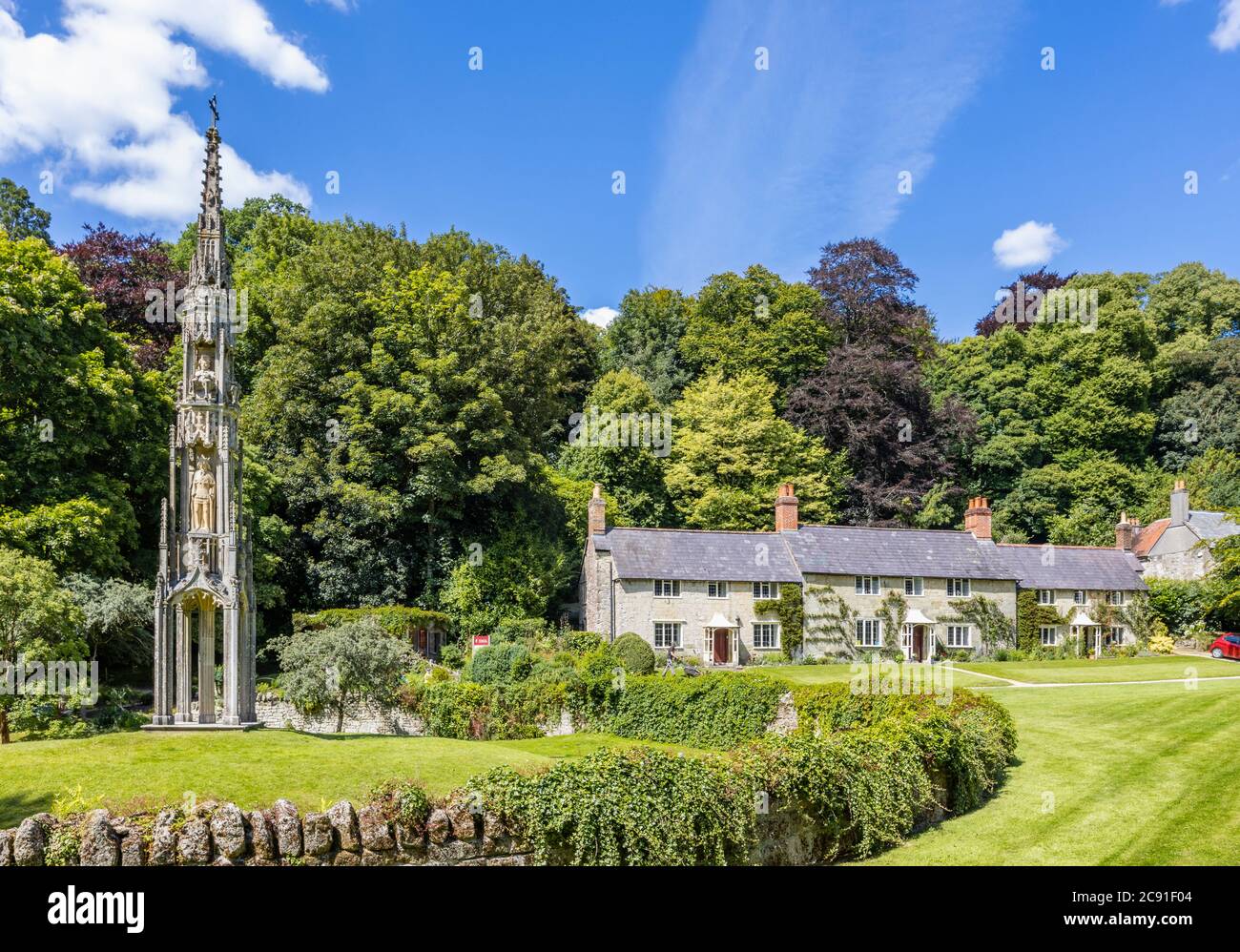 Il Bristol High Cross e una fila di cottage tradizionali in pietra su Church Lawn, Stourton, un piccolo villaggio vicino a Stourhead, Wiltshire, Inghilterra sud-occidentale Foto Stock