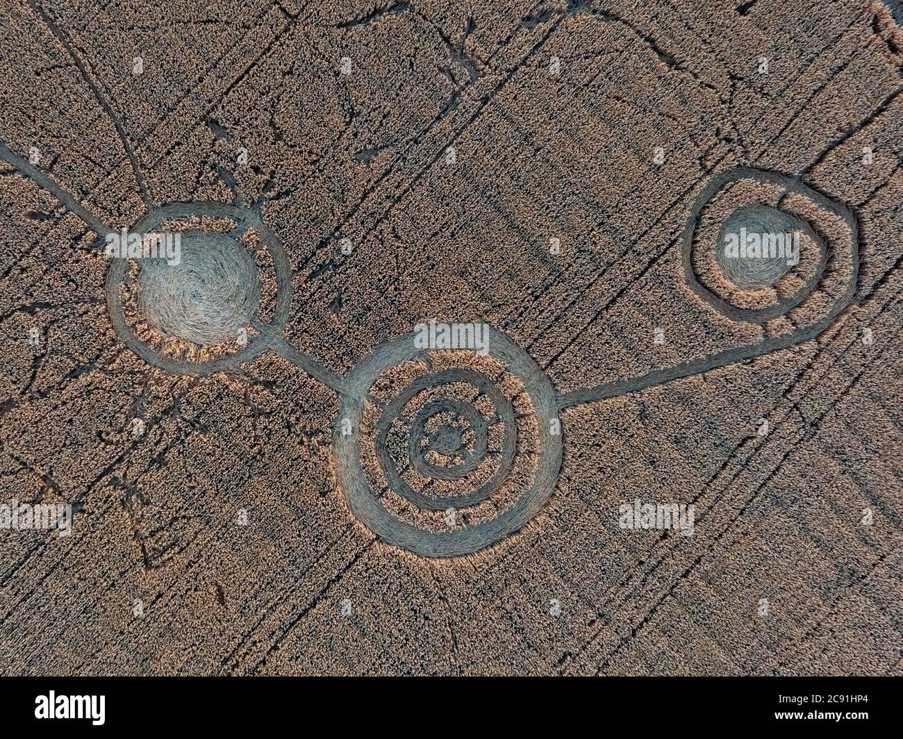 Cerchio di raccolto misterioso in campo di avena vicino alla città, vista aerea Foto Stock