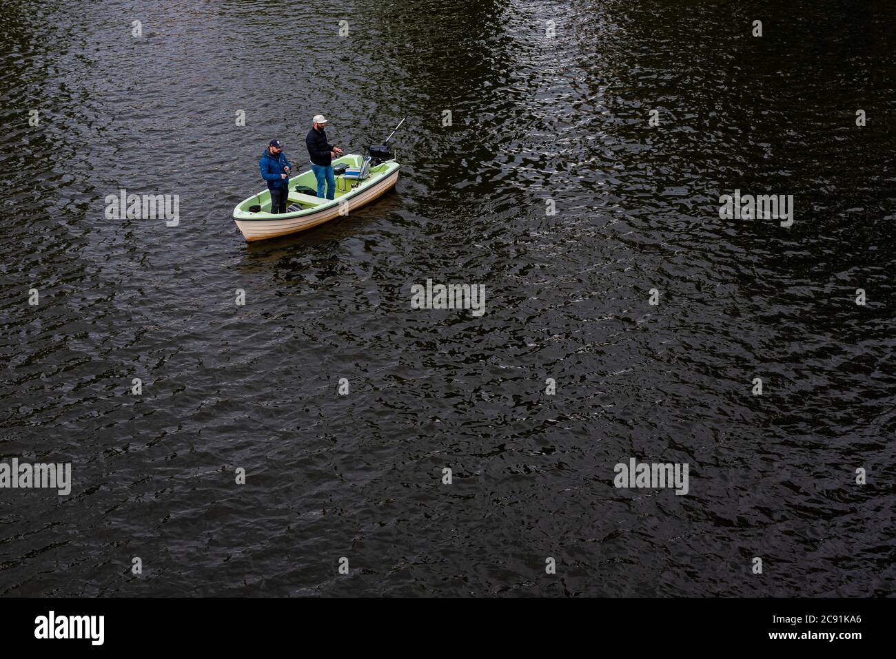 Due uomini pescano da una piccola barca, due pescatori su una barca Foto Stock