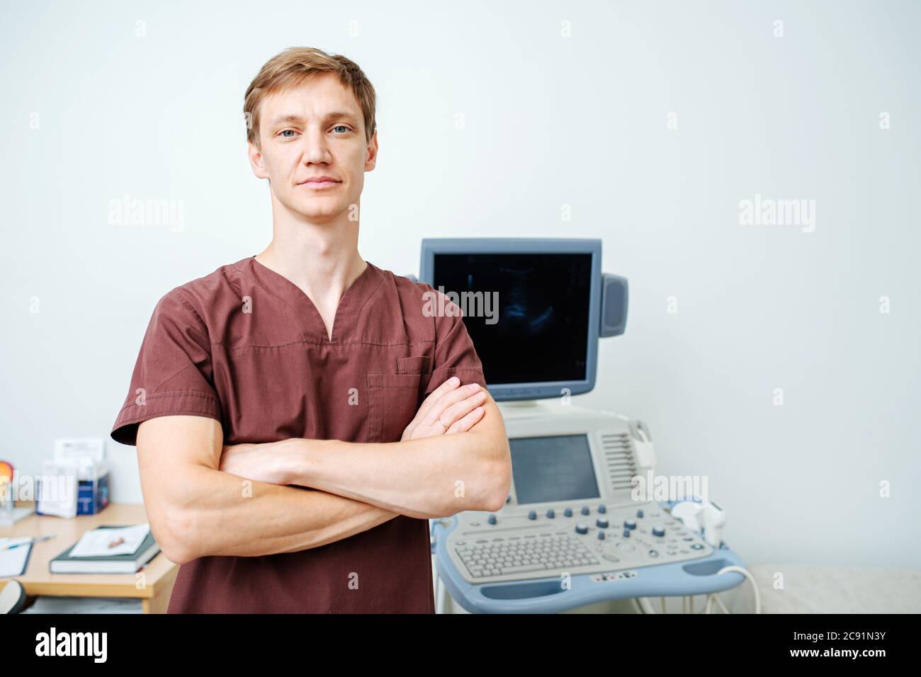 Ritratto di un giovane medico accanto ad una macchina ecografica Foto Stock