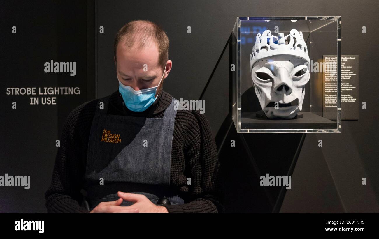 Londra, Regno Unito. 28 luglio 2020. Un membro dello staff che indossa una  maschera accanto a una maschera usata per il live Visual per 'Mad as Hell',  2019, dai Chemical Brothers. Anteprima