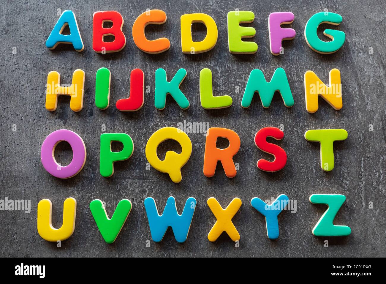 Lettere colorate su sfondo granito, ordine alfabetico, vista dall'alto Foto Stock