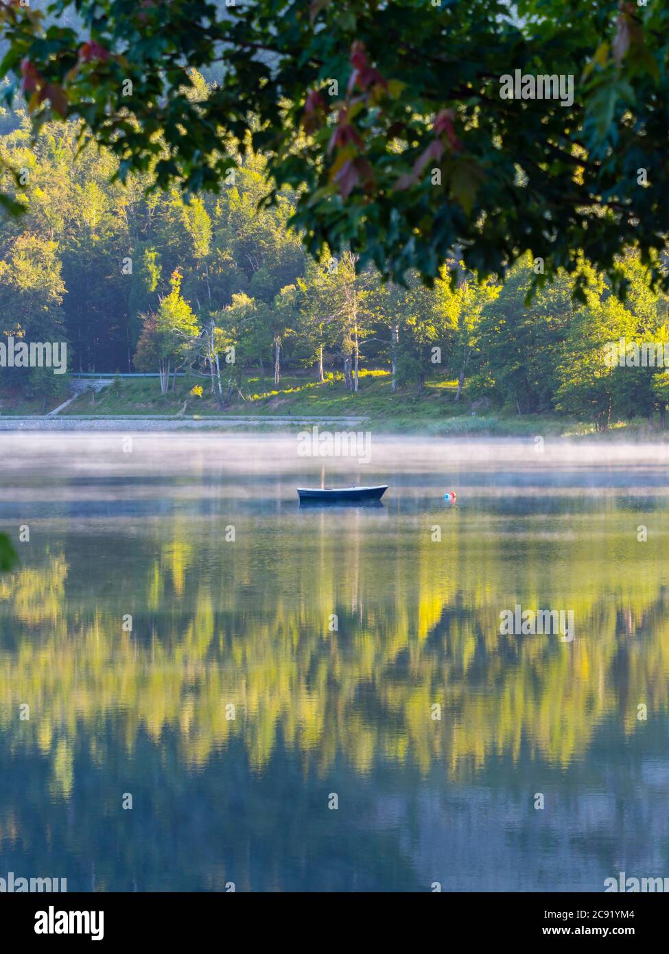 Lonesome barca sul lago Bajer in Fuzine Croazia nebbia d'Europa vapore di nebbia galleggiante appena circa superficie dell'acqua splendida & incredibile e meraviglioso Foto Stock