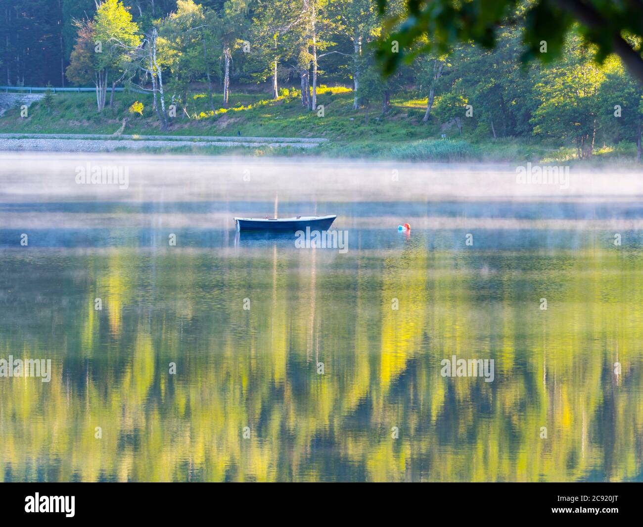Lonesome barca sul lago Bajer in Fuzine Croazia nebbia d'Europa vapore di nebbia galleggiante appena circa superficie dell'acqua splendida & incredibile e meraviglioso Foto Stock