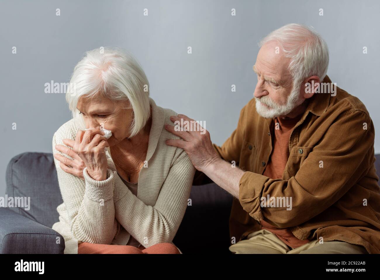 uomo anziano calmando moglie piangendo mentre tocca la sua spalla Foto Stock
