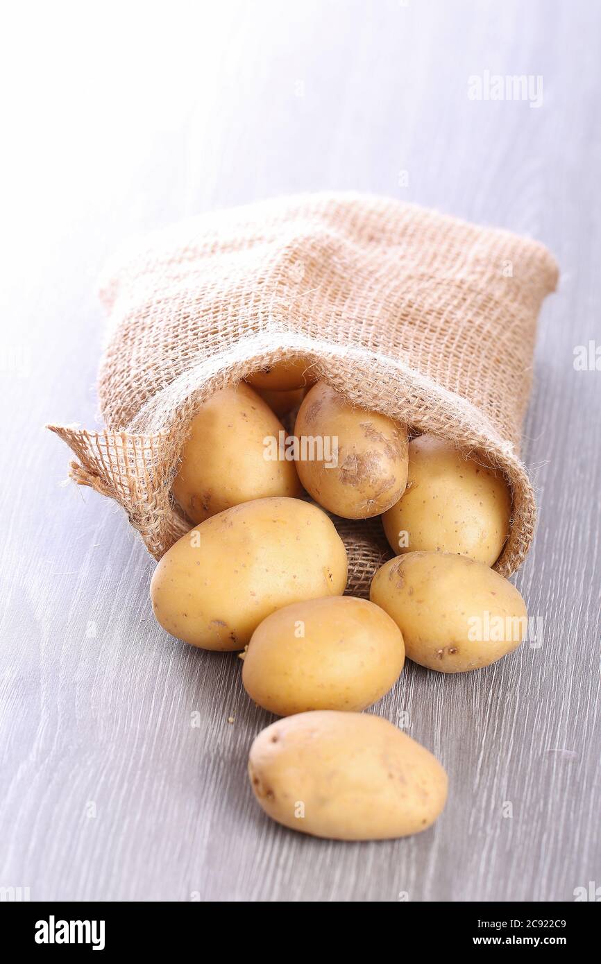 patate su fondo bianco, patate su un tavolo di legno Foto Stock