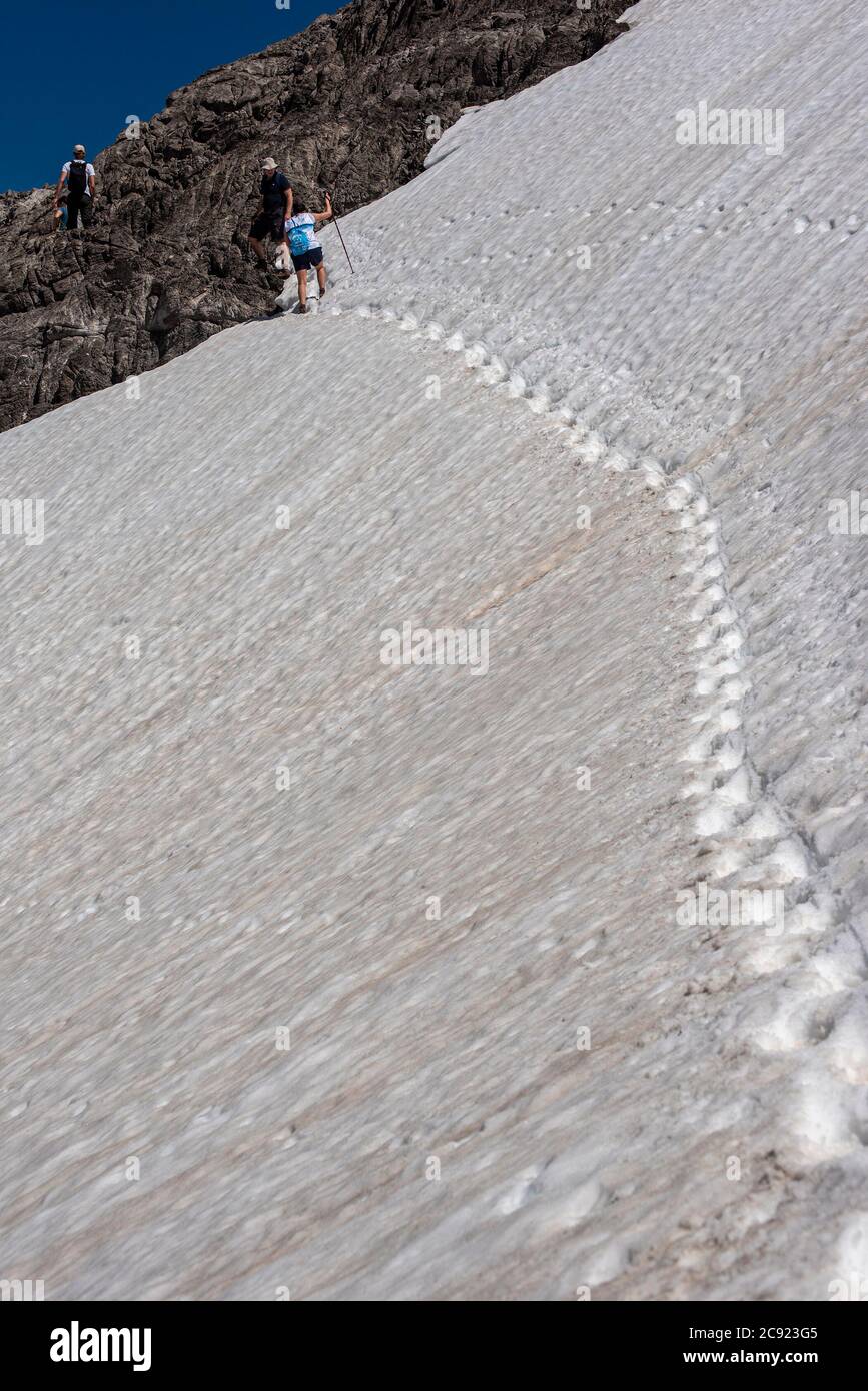 Gli escursionisti attraversano un bordo innevato nelle montagne di Picos De Europa, Spagna Foto Stock